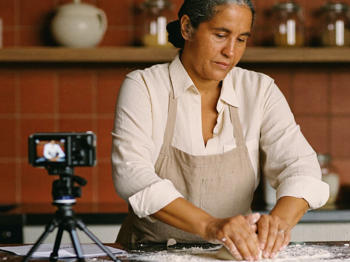 Instructora de repostería amasa mientras graba su clase en línea en su cocina